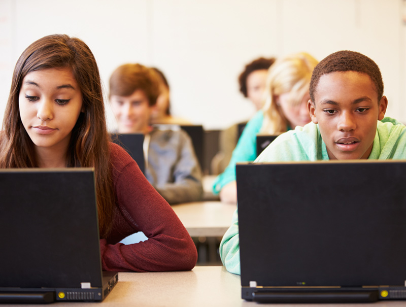 Photo of children at a desk facing forward from a educators point of view.