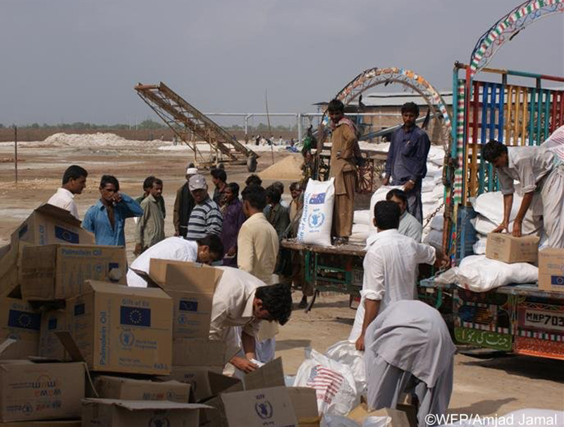 Photo of relief workers unloading sack of food from a truck. Photo copyright Amjad Jamal World Food Programme.